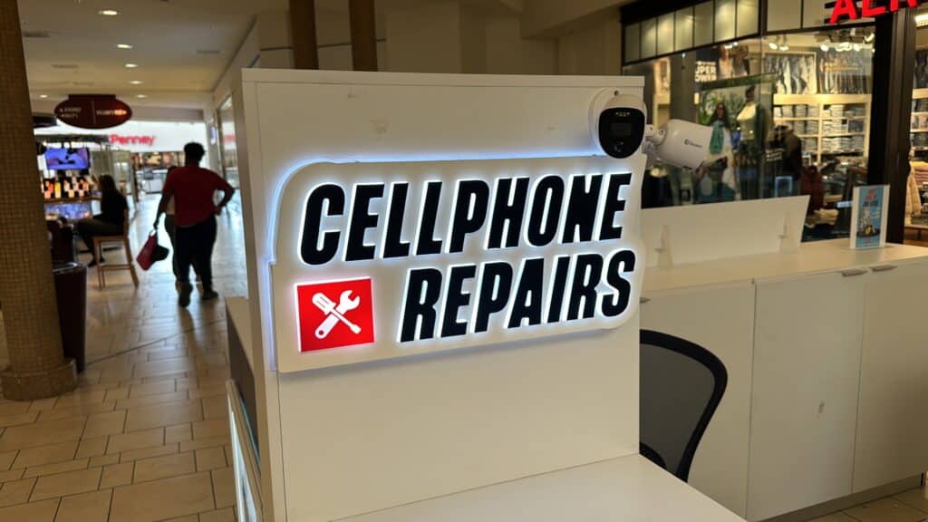 Letrero blanco Cellphone Repairs con icono herramientas rojo interior mall