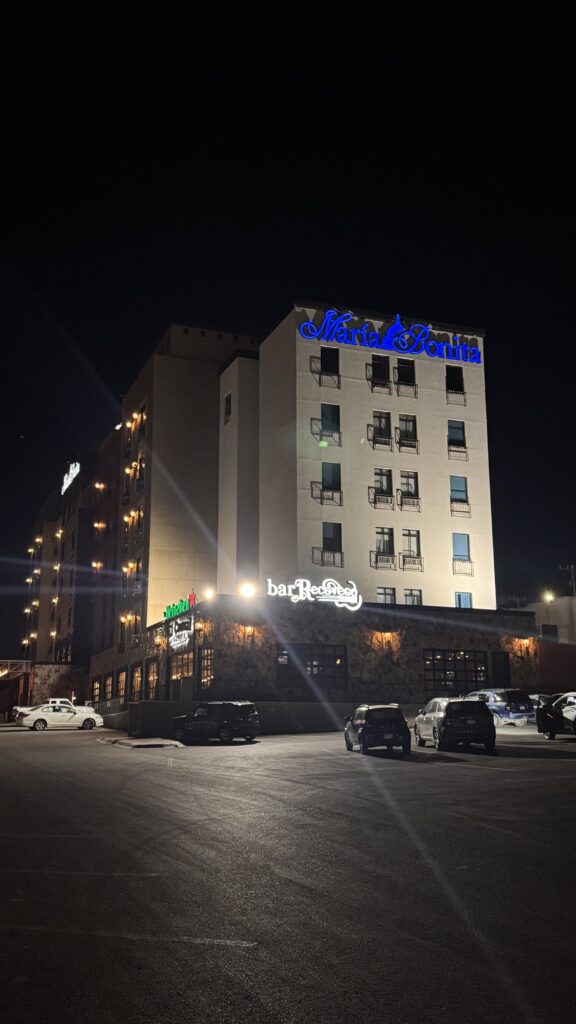 Edificio hotel con letrero María Bonita azul en techo y bar Recoveco abajo