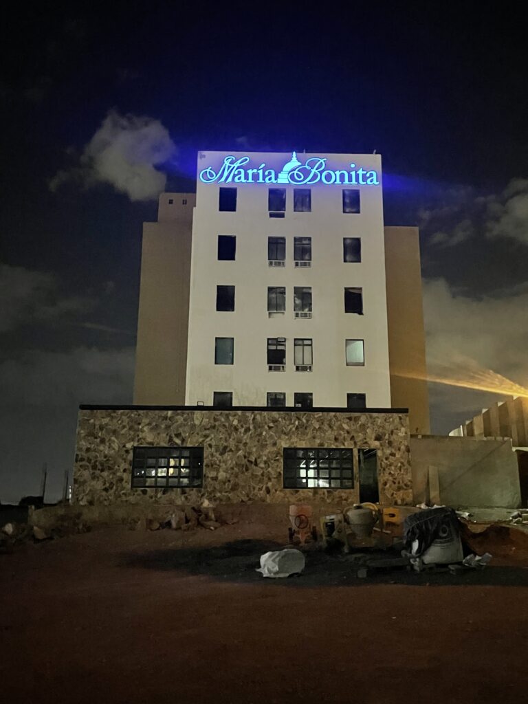 Letrero María Bonita en script blanco con ícono cúpula de noche