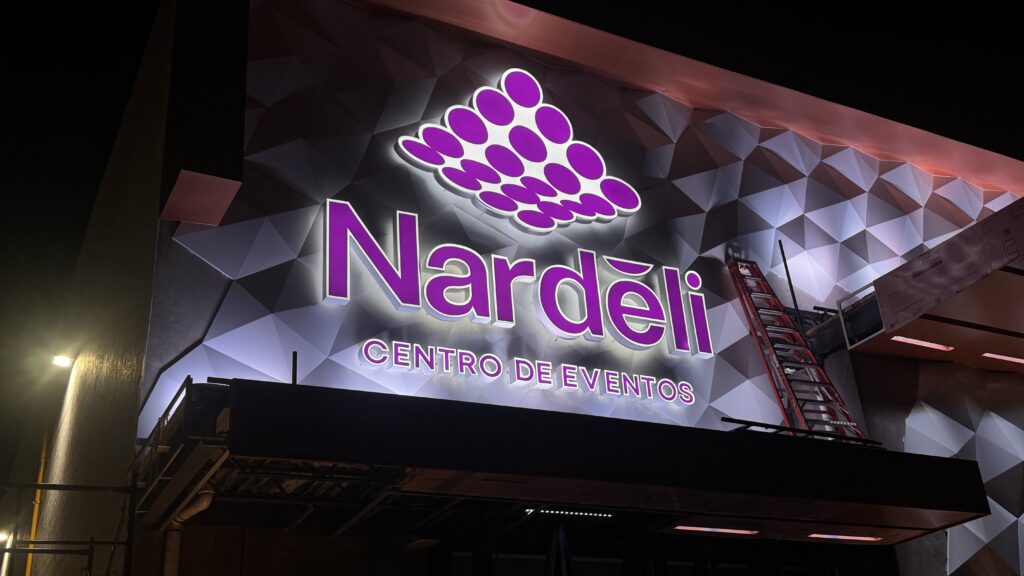 Letrero Nardeli Centro de Eventos en morado con racimo uvas moradas de noche