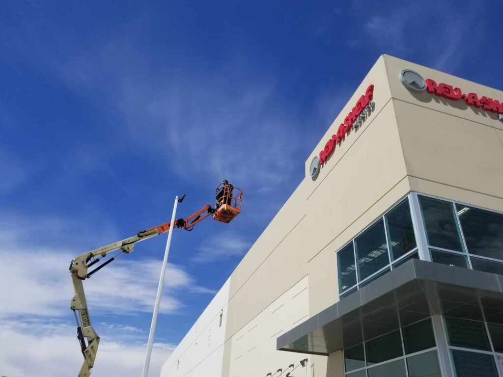 Instalación de letrero Rev-A-Shelf con grua elevadora en edificio de día