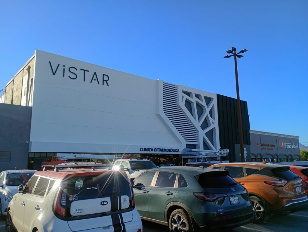 Fachada completa de Clínica Oftalmológica Vistar de día con letrero y cielo azul