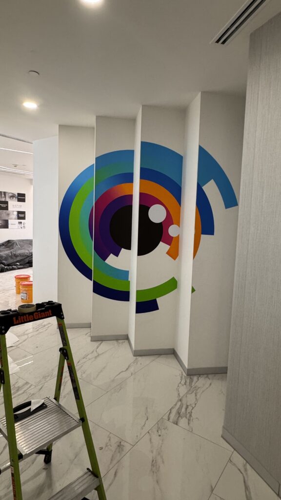 Instalación de logo Vistar con círculos concéntricos de colores formando figura de ojo
