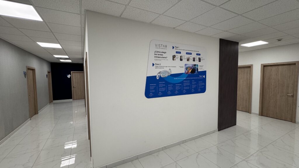 Pasillo interior con impresión digital azul sobre lentes y servicios oftalmológicos Vistar